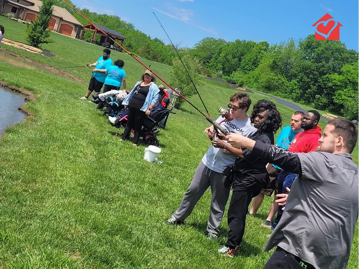 A large group of TNC Community individuals fishing at the pond during Spring Fun Day