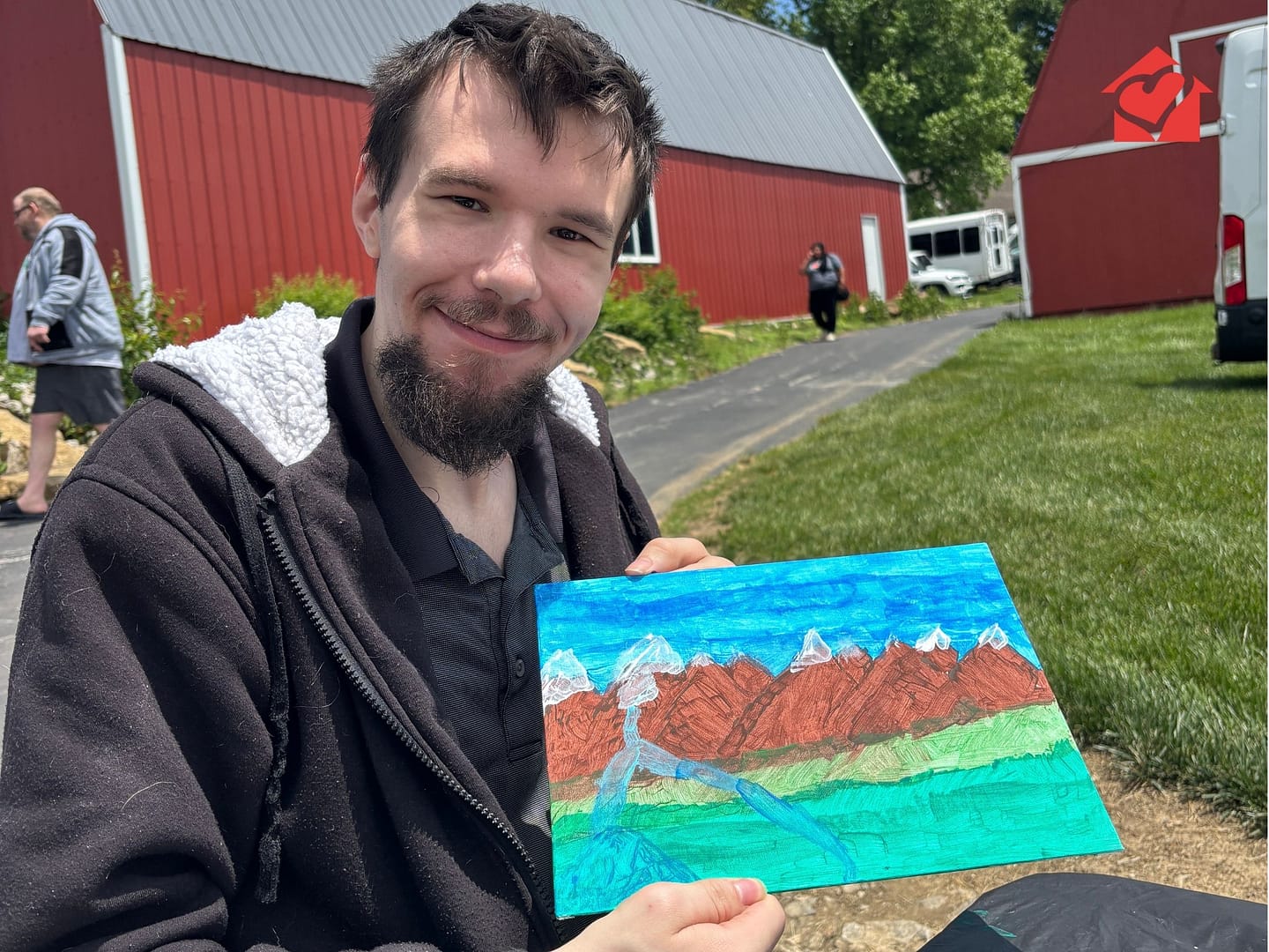 Community connections individual showing off his painting outside at Spring Fun Day