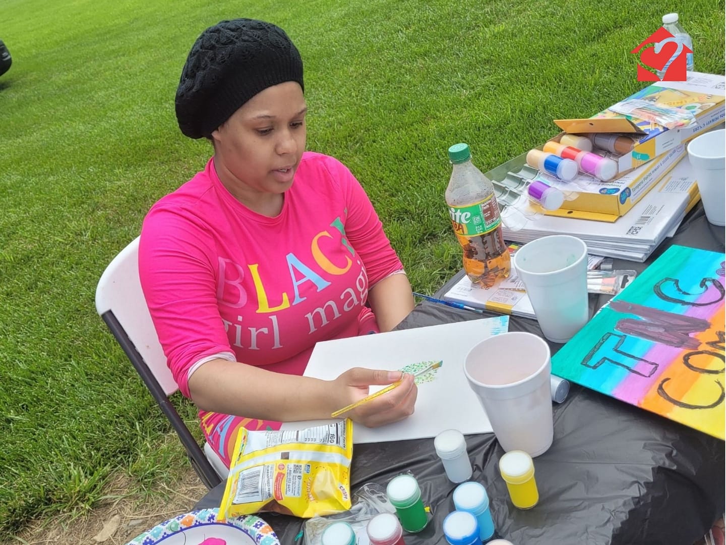 Community connections individual painting outside at Spring Fun Day