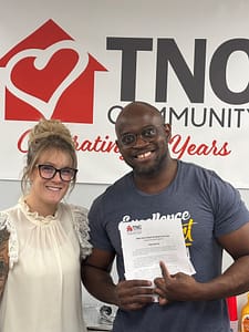 Lacey Taylor, Chief Program Officer, giving Serge Ngounou, DSP, the 2025 Direct Support Employee of the Year award.
